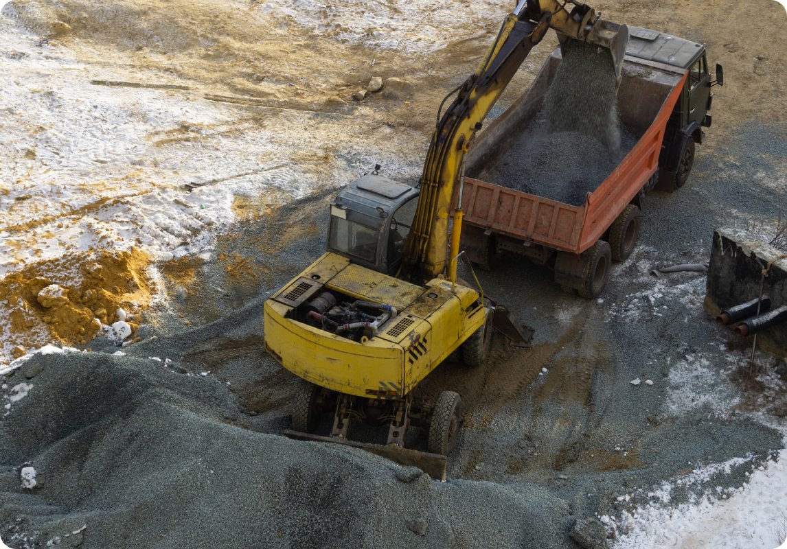 Excavator loading granite into truck